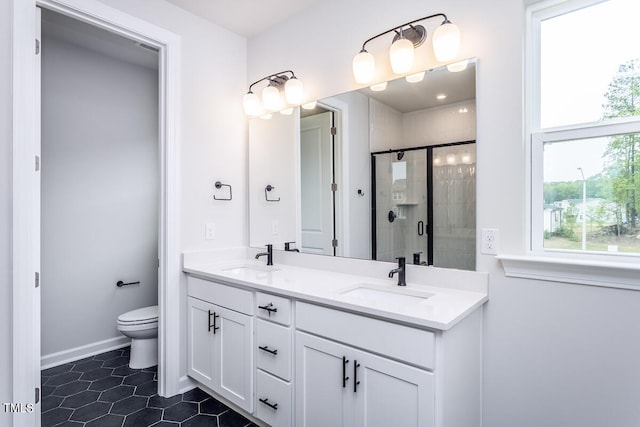 bathroom featuring plenty of natural light, double vanity, tile floors, and toilet