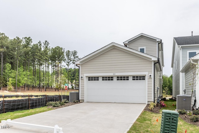 view of front of home featuring a garage and central AC