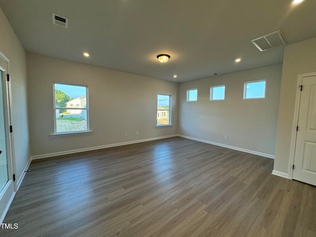 unfurnished room featuring dark hardwood / wood-style flooring and a healthy amount of sunlight