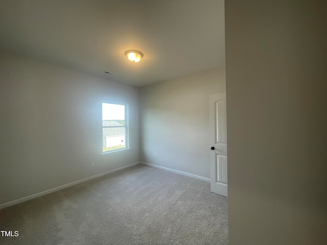 spare room featuring light colored carpet