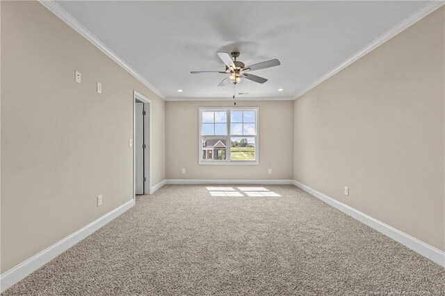 carpeted spare room with ceiling fan and crown molding