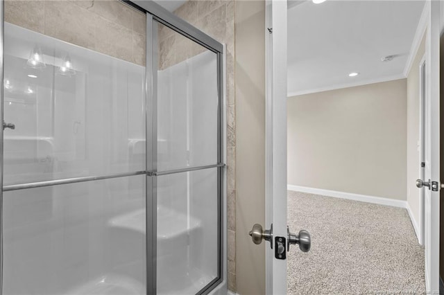 bathroom featuring a shower with shower door and ornamental molding