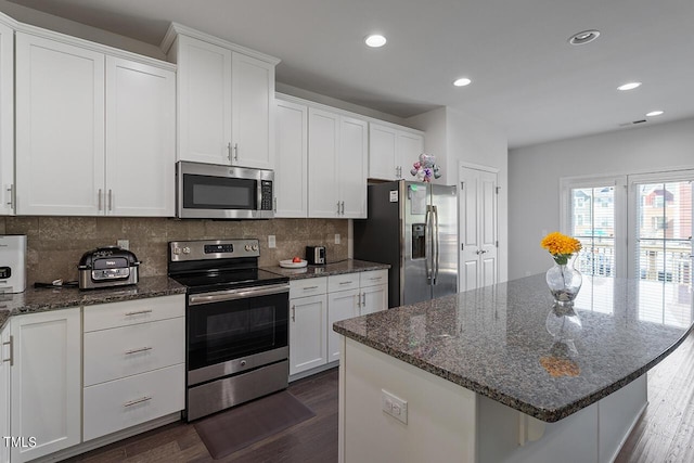 1001 Drayman Pl, Apex, NC 27502 - kitchen with appliances with stainless steel finishes, white cabinetry, dark wood-style flooring, decorative backsplash, and recessed lighting