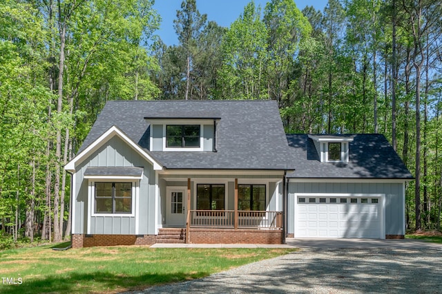 view of front facade featuring a porch, a garage, and a front yard