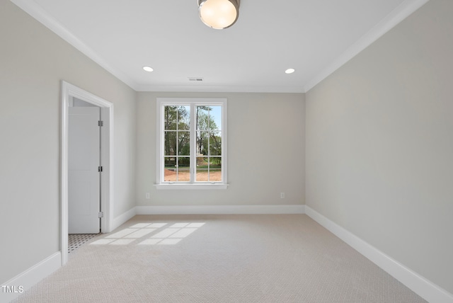 spare room featuring light colored carpet and crown molding