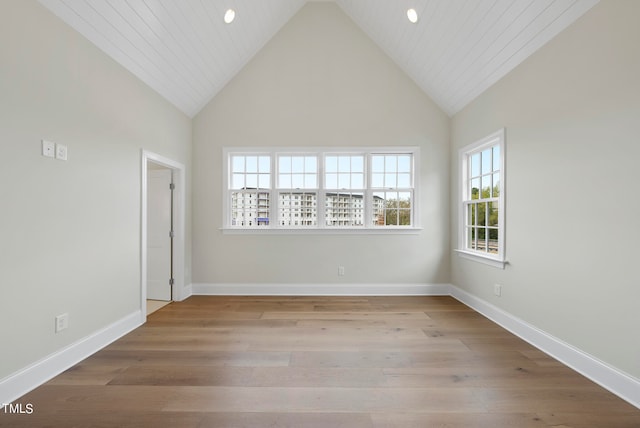 spare room featuring high vaulted ceiling and hardwood / wood-style flooring