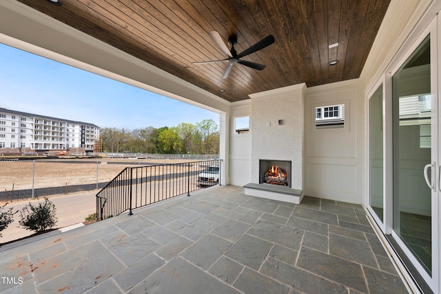 view of terrace featuring a large fireplace and ceiling fan