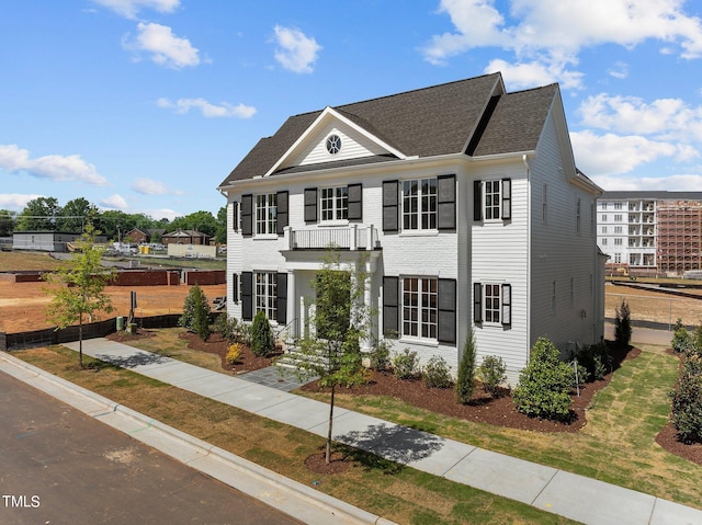 view of front of property with a balcony and a front yard