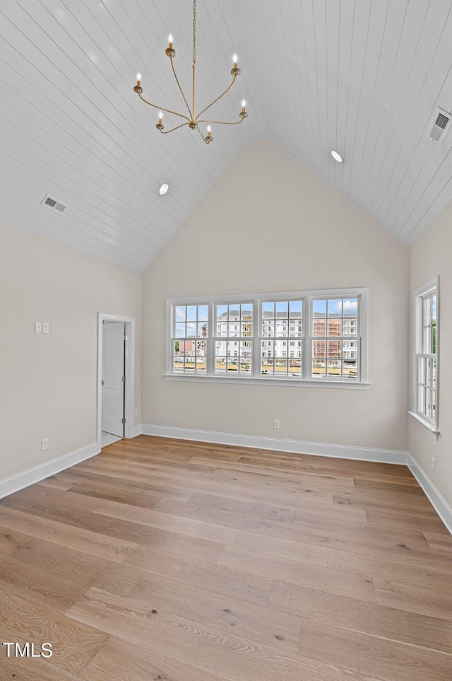 empty room with high vaulted ceiling, light hardwood / wood-style floors, and plenty of natural light