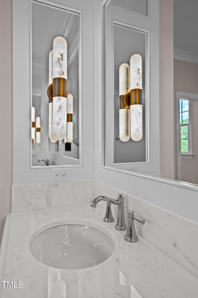 bathroom with crown molding and sink