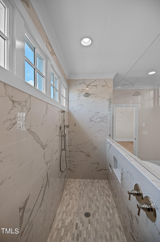 bathroom featuring tiled shower and tile walls