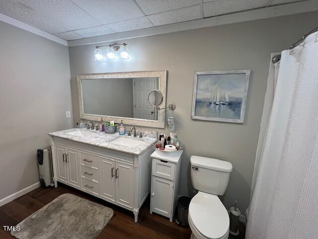 bathroom featuring a paneled ceiling, vanity, wood-type flooring, and toilet