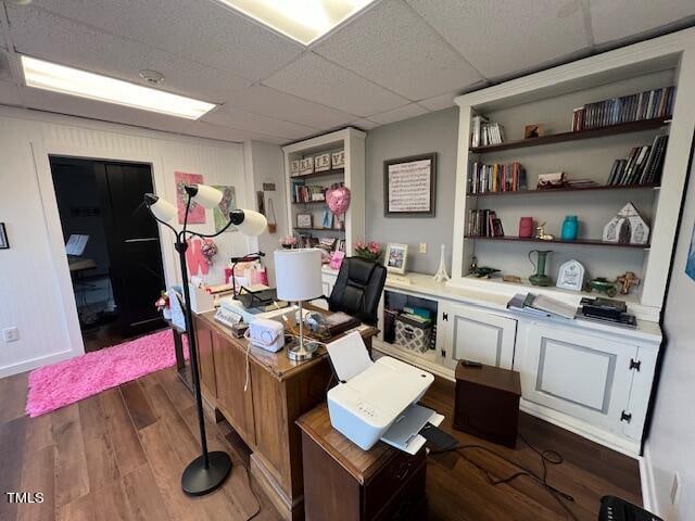 home office featuring a drop ceiling and dark wood-type flooring