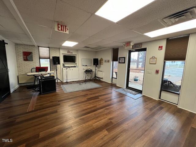 interior space featuring a drop ceiling and dark hardwood / wood-style flooring