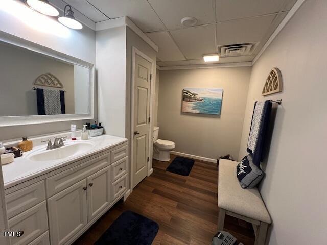 bathroom featuring ornamental molding, vanity, wood-type flooring, and toilet