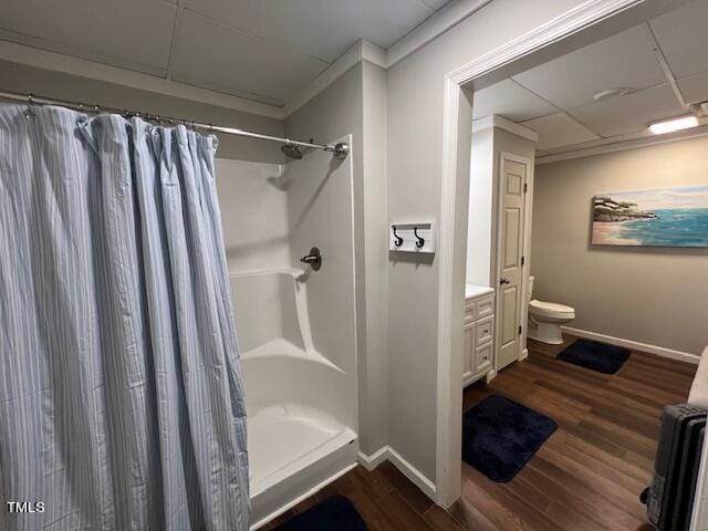 bathroom with a shower with curtain, toilet, ornamental molding, and hardwood / wood-style floors