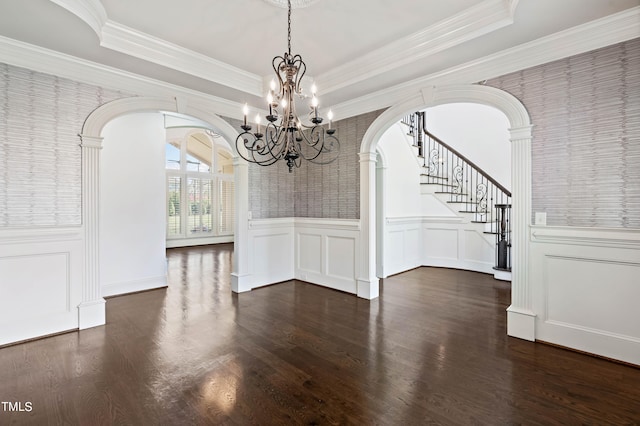 unfurnished dining area with an inviting chandelier, crown molding, dark hardwood / wood-style floors, and a raised ceiling