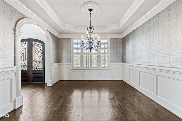 entryway with a chandelier, ornamental molding, dark hardwood / wood-style floors, a tray ceiling, and french doors