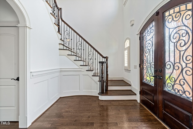 entryway featuring french doors, dark wood-type flooring, and a high ceiling