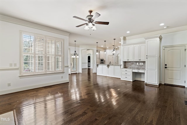 unfurnished living room with ornamental molding, ceiling fan, dark wood-type flooring, and sink