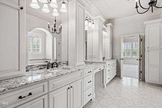 bathroom featuring a notable chandelier, tile floors, vanity, and a wealth of natural light