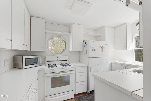 kitchen with white cabinets, white appliances, and sink