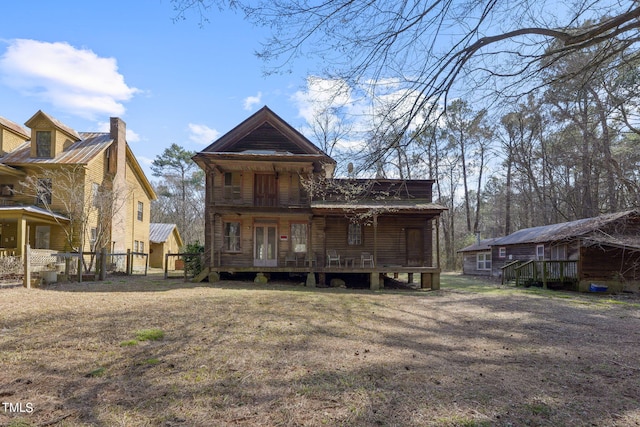 back of house featuring covered porch and a lawn