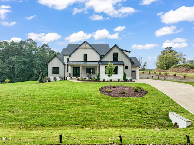 modern farmhouse featuring a garage, a porch, and a front lawn