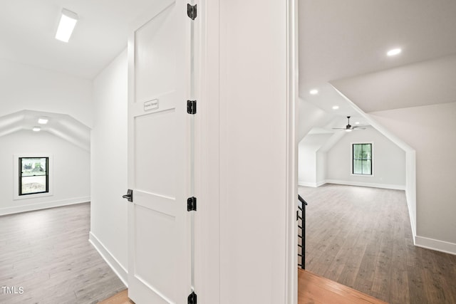 hallway featuring lofted ceiling and hardwood / wood-style flooring