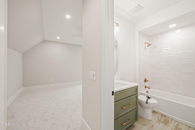 full bathroom featuring tiled shower / bath combo, vanity, toilet, and vaulted ceiling