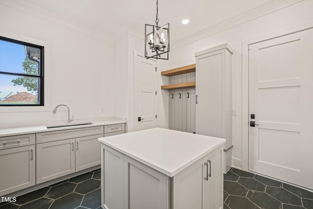 interior space featuring a notable chandelier, crown molding, sink, and dark tile patterned floors