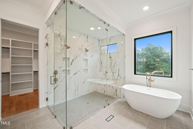 bathroom featuring shower with separate bathtub, ornamental molding, and hardwood / wood-style floors