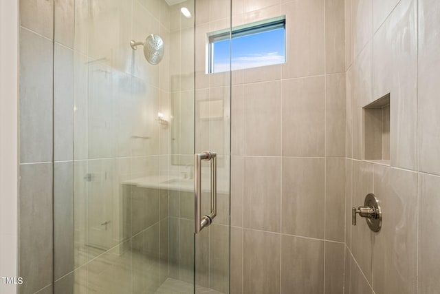 bathroom with a shower with door