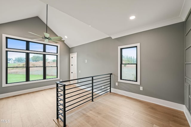 unfurnished room with crown molding, lofted ceiling, ceiling fan, and light hardwood / wood-style flooring