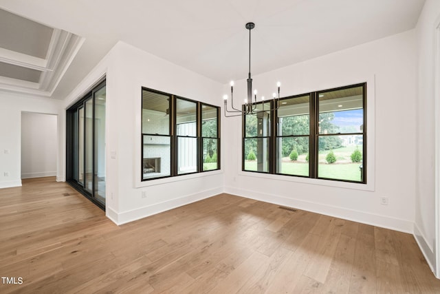 unfurnished dining area featuring light hardwood / wood-style flooring, an inviting chandelier, and a healthy amount of sunlight