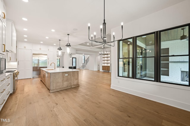 kitchen with a spacious island, white cabinets, pendant lighting, and premium appliances