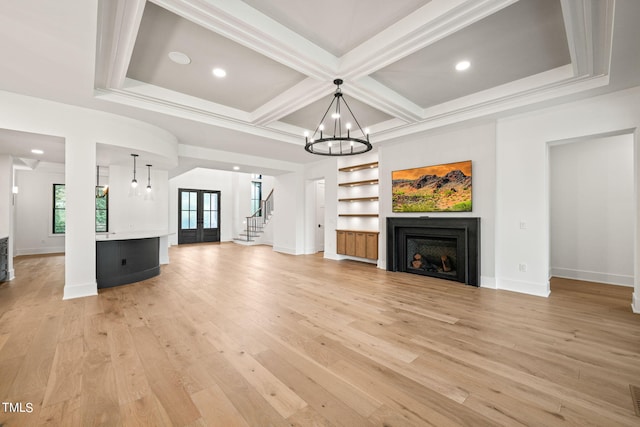 unfurnished living room featuring light hardwood / wood-style flooring, beam ceiling, coffered ceiling, and an inviting chandelier