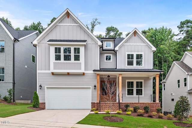 view of front facade featuring driveway, roof with shingles, covered porch, board and batten siding, and brick siding