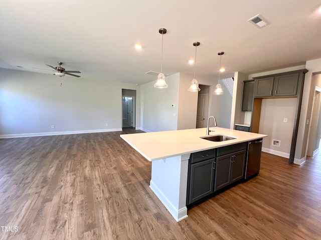 kitchen with decorative light fixtures, a center island with sink, dark hardwood / wood-style floors, and sink