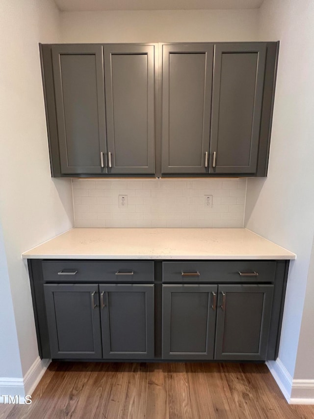 details featuring wood-type flooring and backsplash