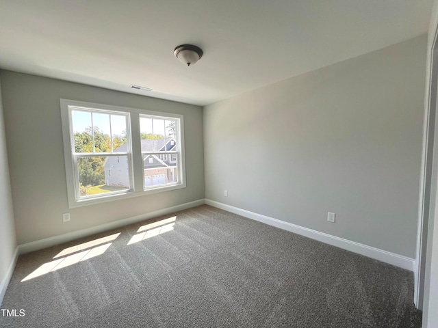 spare room featuring dark carpet