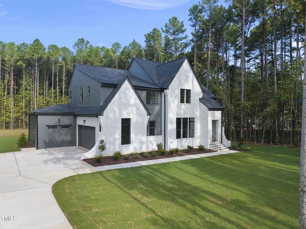 modern inspired farmhouse featuring a front lawn and a garage