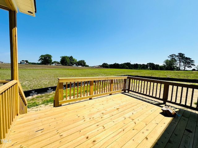 wooden deck with a yard and a rural view