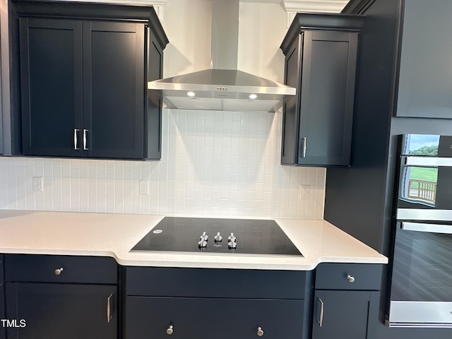 kitchen featuring stainless steel double oven, wall chimney range hood, black electric cooktop, and tasteful backsplash