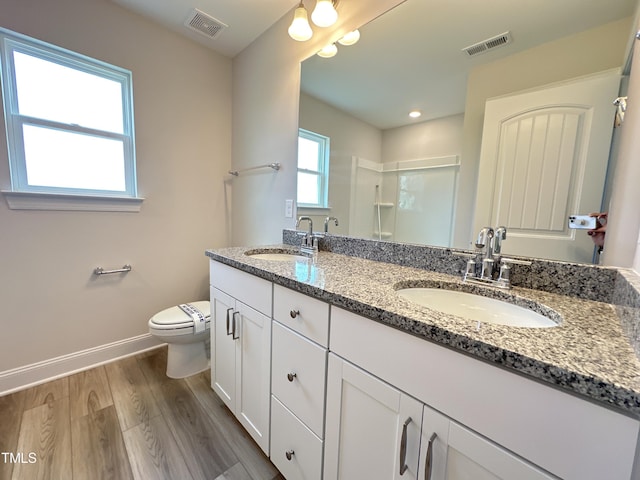 bathroom featuring toilet, hardwood / wood-style floors, walk in shower, and vanity