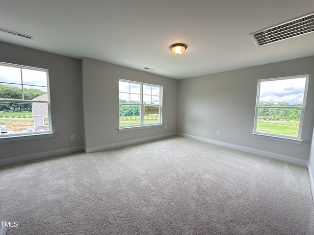 unfurnished room with light carpet and plenty of natural light