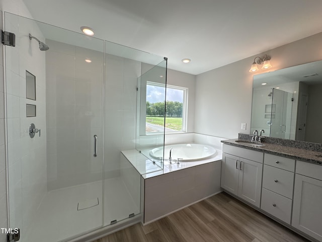 bathroom with hardwood / wood-style floors, vanity, and separate shower and tub