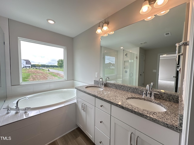 bathroom with independent shower and bath, hardwood / wood-style flooring, and vanity