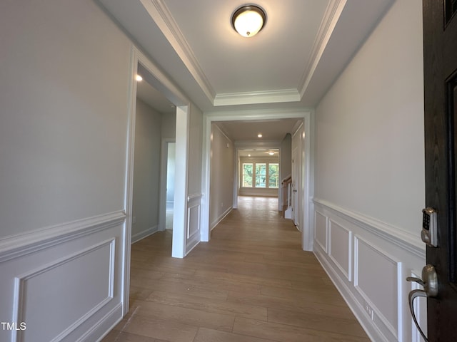 hall featuring ornamental molding and light hardwood / wood-style floors