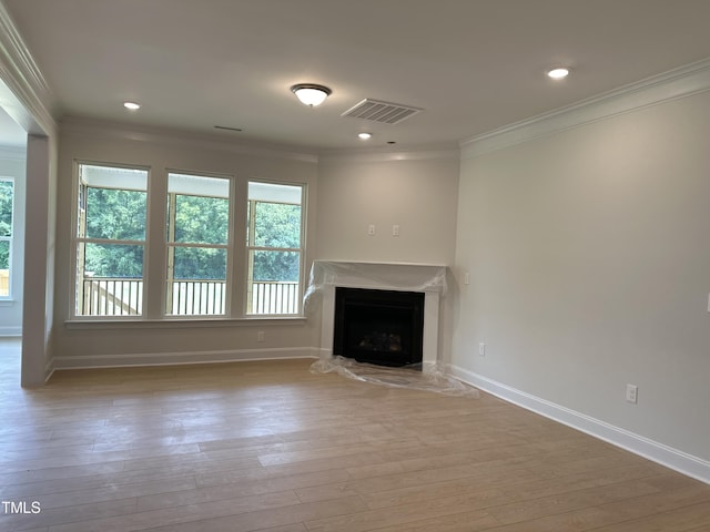 unfurnished living room featuring light wood-type flooring and ornamental molding